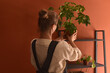 © Amor Burakova/Stocksy - Woman arranges plants at home