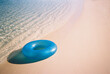 © Cara Dolan/Stocksy - Film photo of blue inner tube on beach