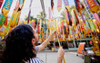 © Edu Bastidas + David Garcia/Stocksy - Man placing hanging decorations at temple in Thailand