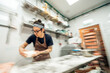 © Santi Nuñez/Stocksy - Baker kneading dough in commercial bakery kitchen