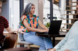 © Jovo Jovanovic/Stocksy - Woman works on laptop during meeting with colleagues.