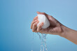 © Marc Tran/Stocksy - hand squeezing water from a white cloth against a gradient blue