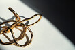 © Vera Lair/Stocksy - Gold Wire Sculpture on Table With Shadows in Afternoon Light