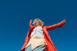 © Basil Pind/Stocksy - Stylish person using smartphone outdoors under clear blue sky