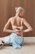 © Serge Filimonov/Stocksy - Slim woman in lingerie and blue skirt kneeling indoors