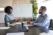 © Niyaz Tavkaev/Stocksy - Diverse coworkers talking during conference