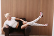 © Serge Filimonov/Stocksy - Portrait woman sit on chair with polka dot pantyhose