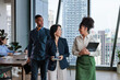 © Jovo Jovanovic/Stocksy - Diverse business team in modern office with city view.