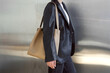 © Amor Burakova/Stocksy - Woman carrying beige leather bag