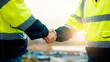 © peopleimages.com - People, engineer and meeting with handshake on rooftop for building deal or partnership in city. Contractor, builder or shaking hands with flare for teamwork or agreement on construction site