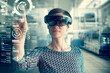 © Westend61 - Woman wearing mixed reality smartglasses touching transparent screen