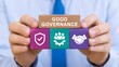 © emwe studio - Businessman holding wooden blocks with good governance text and corporate icons representing ethical management compliance and business partnership