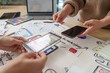 © Natee Meepian - Women designers using transparent phone for AR mobile app UI UX prototyping