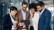 © BAGAS - Diverse Business Team Looking at Tablet in Modern Office