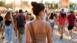 © AZ Studio - Diverse crowd of people walking towards a music festival entrance gate at sunset
