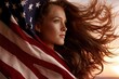 © whitestorm - Patriotic young woman with flowing hair wrapped in the American flag against a sunset sky.