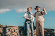 © luciano - Joyful senior couple enjoying outdoors excursion taking a selfie from the top of a mountain. Cheerful man and woman at the sunset light taking breath and smiling