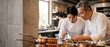 © Fernando - Two Asian chefs plating gourmet dish in a professional restaurant kitchen, senior head chef mentoring young apprentice, culinary team working with precision, high-end fine dining restaurant banner.
