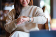 © Farknot Architect - Closeup image of a woman checking time and pointing finger at a watch