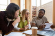 © Danil Nevsky/Stocksy - Diverse students collaborating on assignment in library