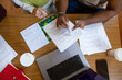 © Danil Nevsky/Stocksy - Students studying together on desk with laptop