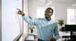 © Vyatcheslav - Black businessman pointing at a bar chart on a screen during a presentation. Professional man in glasses explaining data in a bright office. Corporate training and analysis concept