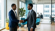 © OlgaNeuroArt - Two smiling Black businessmen shaking hands in a modern office. African American corporate professionals sealing a deal or greeting. Successful business partnership concept