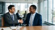 © Eve - Professional handshake between indian and black business executives sitting at conference table in office commercial partnership concept