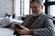 © opolja - Mature smiling man using smartphone