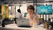 © DC Studio - Female worker analyzing income data and performance metrics in a corporate office, Woman working on laptop with analytics and charts, supporting resource allocation and business strategy.