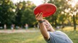 © MT - Young Caucasian man throwing red frisbee in sunny park during summer outdoor recreational activity