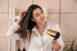© Pixel-Shot - Pretty young woman with hair dryer in bathroom