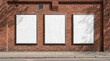 © pixs4u - Three blank vertical poster frames mockup on outdoor red brick wall with sunlight shadows