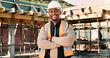 © peopleimages.com - Crossed arms, happy and portrait of African man on construction site for infrastructure career. Architecture, contractor and person with ppe for safety compliance, renovation project and building