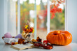 © Volodymyr - Autumn home vibes with mulled wine and candles. Autumn vibes with books. Fall atmosphere. Autumn fall leaves and warm tea. Autumn fall vibes with pastry and mulled wine.