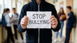 © Emre Akkoyun - Student holding stop bullying sign in school corridor, promoting anti bullying awareness and support campaign