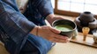 © 恵美 國重 - 茶室の落ち着いた空間の中で、着物を着た女性が茶碗を持つ手元をクローズアップで捉えた構図。和紙や畳を感じさせる背景が日本の伝統文化を演出している。柔らかな自然光が茶碗や着物の質感を美しく引き立てる。茶道、おもてなし、礼儀、和文化、精神性を表現するコンセプト素材