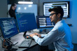 © Jestercine - Male Developer Coding At Multiple Monitors In Dark Office