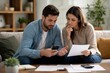 © Olena Apetroaiei - Serene home moment as a couple diligently manages their financial landscape