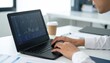 © davidolgade - Businessman trading stocks on a laptop in bright office.