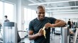 © mashimara - Fit man smiling while peeling a banana after a workout at the gym