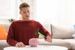 © New Africa - Man breaking piggy bank with hammer at white table indoors, space for text