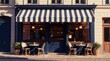 © Pete - European cafe storefront with striped awning and outdoor seating. Two rattan chairs and tables sit on cobblestone sidewalk. Building facade features classic architecture and dark blue doors.
