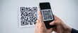 © Olga Ко - Close-up of male hands holding a smartphone and scanning a QR code on a white wall. Contactless digital technology and mobile payment concept