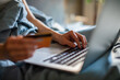 © Davor - Hands paying online with credit card on laptop at home