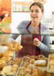© JackF - Young woman seller putting fresh pastries on plate in cafe bakery