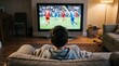 © fadhel - Man watching soccer on television screen.