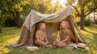 © velikiyzayats - Happy Caucasian children boy and girl playing in a handmade blanket fort in a sunny garden, childhood imagination and outdoor summer adventure concept, cozy backyard playhouse