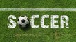 © Gennyson Marinho - A close up view of a black and white soccer ball resting on vibrant green grass with the word 'soccer' boldly painted in white symbolizing the excitement of the sport in a lively