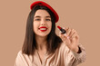 © Pixel-Shot - Beautiful young woman with red lips and lipstick on brown background